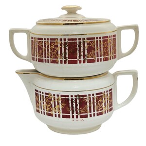 May include: A white ceramic coffee pot with a red and gold plaid design. The pot has a separate top section for brewing coffee and a lower section for serving. The pot has a gold trim around the top and bottom.