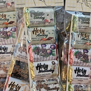 May include: A set of chocolate bars in clear plastic packaging with a header card titled Journey Through Holy Week with prayer and chocolate. Each bar features a specific day of Holy Week with illustrations and text describing events.