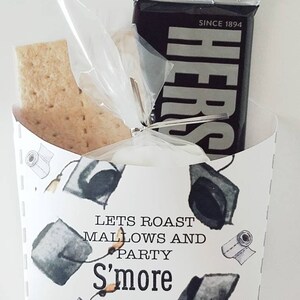 May include: A white paper box with a graduation cap pattern and the text "Lets Roast Mallows and Party S'more". The box contains a graham cracker, a marshmallow, and a Hershey's chocolate bar.