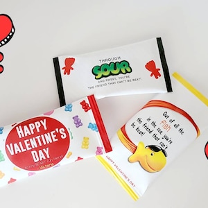May include: Three Valentine's Day themed candy wrappers with different designs. The first wrapper features a red heart with the text "Happy Valentine's Day" and gummy bears. The second wrapper features a green sour gummy with the text "Through Sour and Sweet, You're the Friend That Can't Be Beat!" The third wrapper features a yellow fish with the text "Out of all the fish in the sea, you're the friend that can't be beat!"