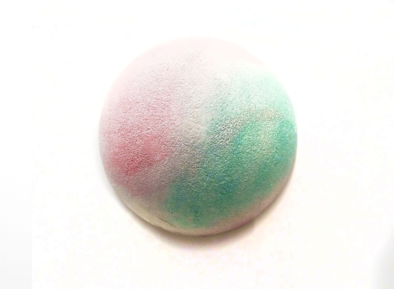 This is a gem of a bath bomb, with a gentle refined fragrance made of cherry blossoms, mimosa flower petals, tonka beans, and warm notes of vanilla.  This 4.5 oz bath bomb will turn the water into a deep amethyst purple. It is 3 inches long by 3 inches wide and 1 inch deep.  All our bath