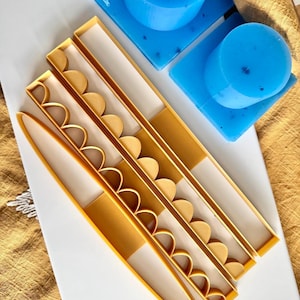 Könnte beinhalten: Ein Satz aus vier gelben Kunststoff-Kuchendekorationstools mit gewellten Kanten. Die Werkzeuge sind nach Größe geordnet, wobei das größte Werkzeug oben und das kleinste unten liegt.