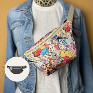 May include: A white fanny pack with a colorful print of Winnie the Pooh and his friends. The fanny pack has a gold zipper and a white strap.