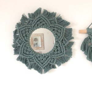 Peut inclure: Un miroir rond avec un cadre en macram&eacute; de couleur vert sauge. Le cadre a un motif en &eacute;toile avec des franges autour des bords.