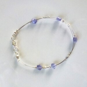 fine bracelet composed of purple mother-of-pearl stars and round silver metal beads mounted on cables, carabiner closure