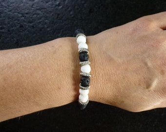 bracelet 20.5 cm en perles de lave rondes noires et blanches, perles rondelles crantées en métal argenté, montées sur fil élastique