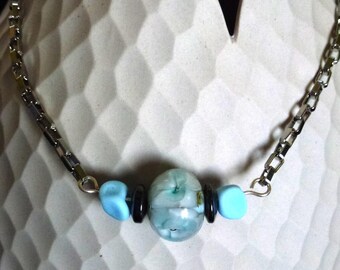 collier avec perle en verre filé au chalumeau motif fleurs bleues et blanches, perles cailloux bleu mat, rondelles hematite, chaine argentée