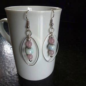 Blue ceramic pearl earrings and pink quartz beads mounted in oval rings and silver hooks