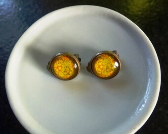 boucles d'oreilles clips avec cabochons motifs oranges sur fond jaune montées sur clips en métal bronze
