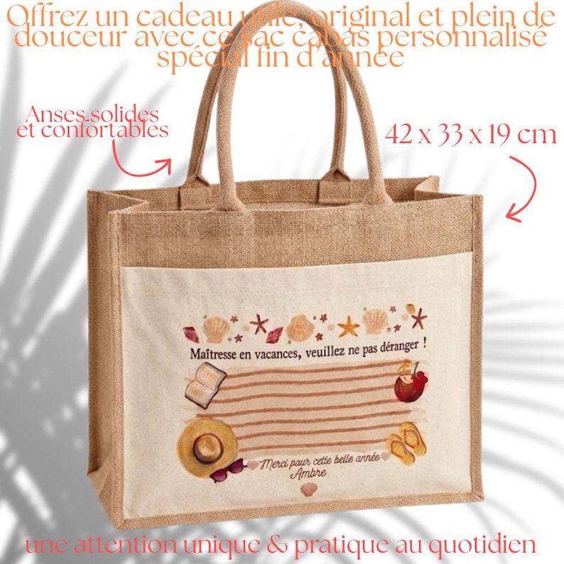 Puede incluir: Bolso tote beige con bolsillo delantero blanco. El bolso presenta un dise&ntilde;o de tem&aacute;tica playera con conchas marinas, un libro, un sombrero y el texto "Ma&icirc;tresse en vacances, veuillez ne pas d&eacute;ranger!". Mide 42 x 33 x 19 cm.