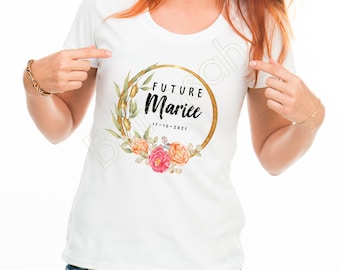 May include: White t-shirt with a gold circle and floral wreath design. The text "Future Mariée" and the date "17-10-2021" are printed inside the circle.