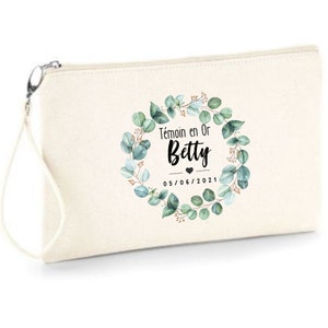 Puede incluir: Una bolsa de maquillaje de lona blanca con un diseño de corona de eucalipto verde. El texto "Temoin en Or Betty 05/06/2021" está impreso en negro en la bolsa.