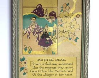Puede incluir: Ilustración vintage enmarcada con un marco plateado. La obra de arte presenta una ilustración de dos figuras en un jardín, con una casa al fondo. Se incluye el texto "MOTHER DEAR" y un poema.