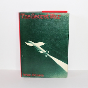 Puede incluir: Un libro titulado "The Secret War" de Brian Johnson. La portada presenta una fotografía en blanco y negro de un avión volando en el cielo nocturno.