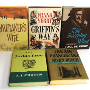May include: A collection of six vintage paperback books with colorful covers. The titles include "Whittaker's Wife", "Griffin's Way", "The Sweeping Wind", "Judas Tree", and "The San Franciscans".