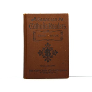 May include: A brown book with the title "CANADIAN Catholic Readers. THIRD BOOK" and the text "PRICE 30 CENTS. THE COPP CLARK COMPANY LIMITED TORONTO" on the cover.