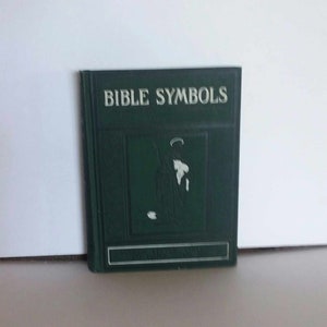 May include: A green hardcover book titled "Bible Symbols" with a white illustration of a person holding a staff and a scroll on the front cover.