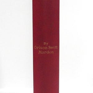 Może przedstawiać: Bordowy grzbiet książki ze złotymi literami. Tytuł "Pushing to the Front" znajduje się na g&oacute;rze, a poniżej "By Orison Swett Marden". Nazwa wydawcy, Houghton Mifflin Co., znajduje się na dole. Książka ma zużyty wygląd.