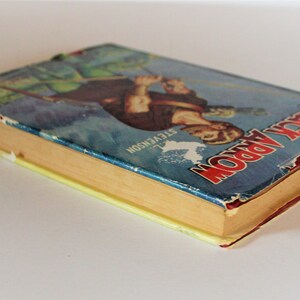 May include: A vintage hardcover book titled "Black Arrow" by R.L. Stevenson. The book cover features an illustration of a man in a green tunic holding a sword and bow and arrow. The book is worn and has a yellowed spine.