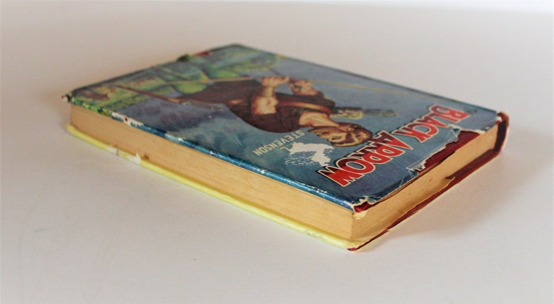 May include: A vintage hardcover book titled "Black Arrow" by R.L. Stevenson. The book cover features an illustration of a man in a green tunic holding a sword and bow and arrow. The book is worn and has a yellowed spine.