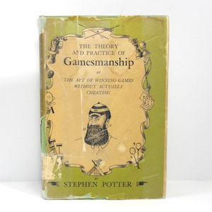 May include: A vintage book titled "The Theory and Practice of Gamesmanship" by Stephen Potter. The cover features a green and tan design with illustrations of game-related objects and a portrait of a man with a beard. The book's title is prominently displayed.