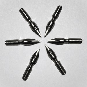 May include: Six silver calligraphy nibs arranged in a star shape on a white background.