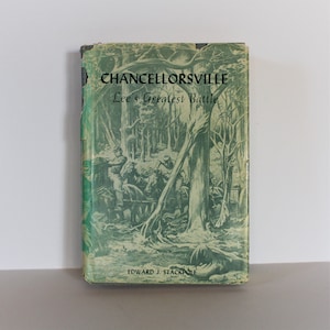 May include: A vintage book titled "Chancellorsville: Lee's Greatest Battle" by Edward J. Stackpole. The cover features a green and white illustration of a battle scene in a forest.