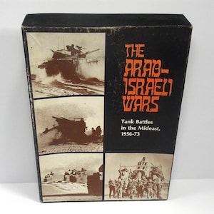 May include: A black box with images of tanks and soldiers. The text on the box reads "The Arab-Israeli Wars" and "Tank Battles in the Mideast, 1956-73". The box has a worn appearance.