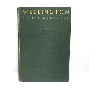 May include: A hardcover book titled "WELLINGTON" by Philip Guedalla. The book has a dark green cover with gold lettering. The spine shows signs of wear.