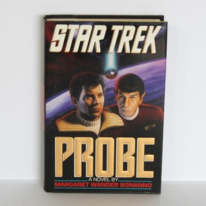 May include: A Star Trek novel titled "Probe" by Margaret Wander Bonanno. The cover features a colourful illustration of Captain Kirk and Spock against a space background.