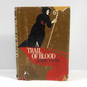 May include: Vintage book cover for "A Trail of Blood" by Jeremy Potter. The cover shows a figure in black robes with a staff, against a brown and red backdrop. The title is displayed in red and white.