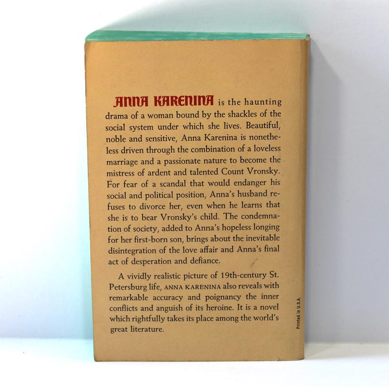 Puede incluir: Contraportada de un libro antiguo titulado "ANNA KARENINA" con texto que describe la trama de la novela. La portada es de color beige con texto rojo y negro, y un borde superior verde. Una novela cl&aacute;sica.