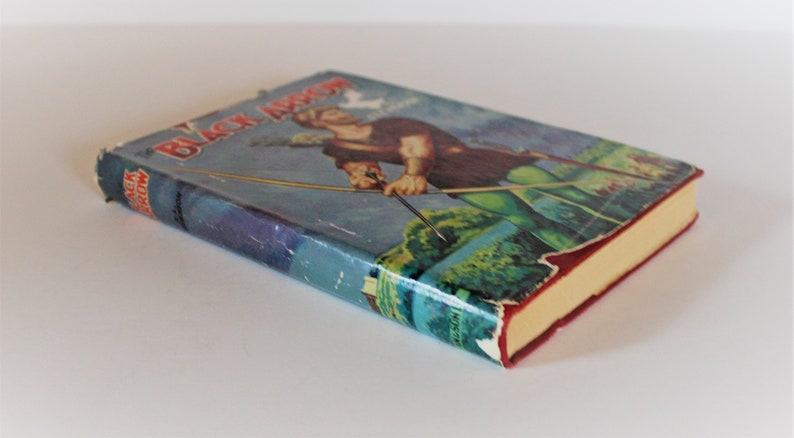 May include: A vintage hardcover book titled "Black Arrow" by Howard Pyle. The cover features an illustration of a man in a green tunic and leggings, holding a bow and arrow, with a forest background.