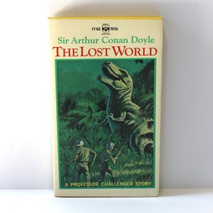May include: Vintage paperback book titled "The Lost World" by Sir Arthur Conan Doyle. The cover features a green and yellow illustration of a dinosaur and two figures in a jungle setting. The book is a "Professor Challenger Story."