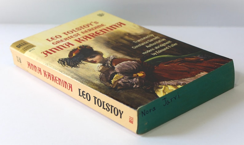 Puede incluir: Un libro de bolsillo vintage titulado "Anna Karenina" de Le&oacute;n Tolst&oacute;i. La portada presenta una ilustraci&oacute;n de una mujer con un vestido. El lomo del libro es verde y el t&iacute;tulo est&aacute; impreso en rojo y negro. El nombre del autor tambi&eacute;n es visible.