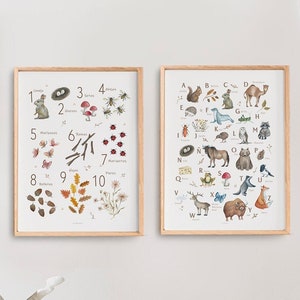 May include: Two framed educational prints with wooden frames. One print features numbers 1-10 with illustrations of plants and animals. The other print displays the alphabet with animal illustrations. The prints are displayed in a child's room.