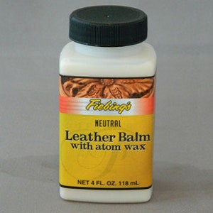 Może przedstawiać: Biała butelka Fiebing's Neutral Leather Balm z woskiem atomowym. Butelka jest oznaczona nazwą produktu i ma czarną zakrętkę. Butelka zawiera 118 ml.
