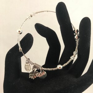Puede incluir: Pulsera de plata con cuentas transparentes, un dije de corazón, un dije de flor y un dije de etiqueta que dice "made for you".
