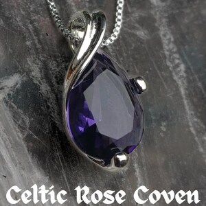 May include: A silver pendant with a large, teardrop-shaped, deep purple gemstone. The pendant is suspended from a delicate silver chain. The text "Celtic Rose Coven" is displayed at the bottom of the image.