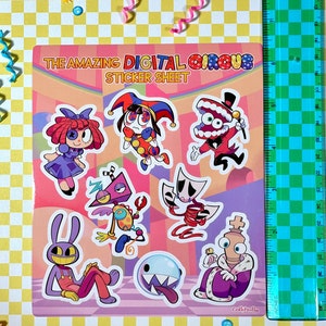 May include: A sticker sheet featuring characters from the "The Amazing Digital Circus" game. The sheet includes a jester, a mouth with teeth, a robot, a ghost, a king, and a rabbit. The sheet is pink and purple with a checkered background.