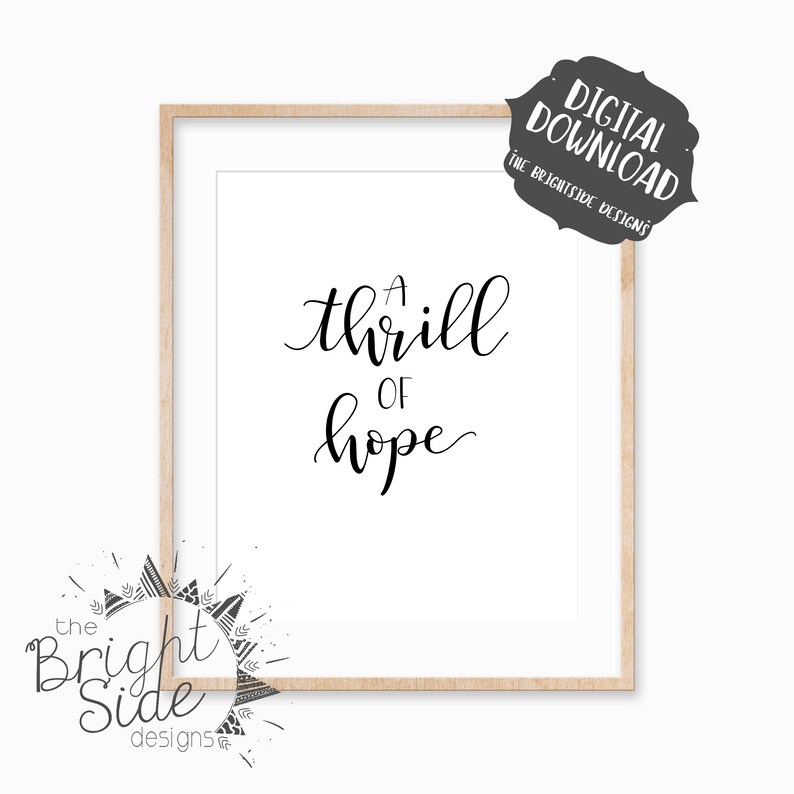 Puede incluir: Una descarga digital imprimible de una cita de caligraf&iacute;a en blanco y negro que dice "A thrill of hope" en un marco de madera.