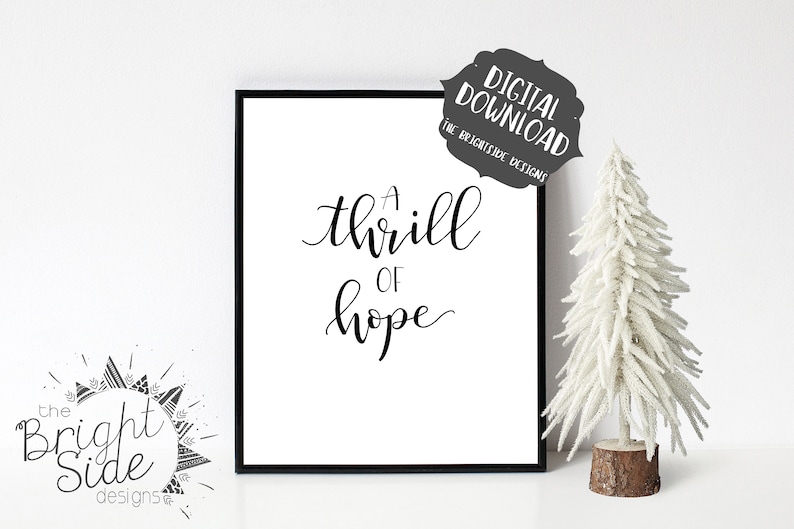 Puede incluir: Una impresi&oacute;n de arte imprimible en blanco y negro con el texto "A thrill of hope" en una fuente cursiva. La impresi&oacute;n est&aacute; enmarcada en un marco negro y se muestra en una pared blanca.