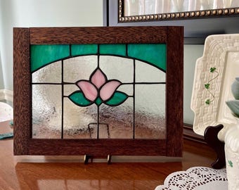 Stained glass window panel with teal and pink flower design.