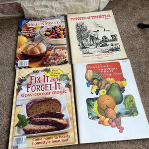 May include: Four cookbooks with colorful covers. The first cookbook is titled "Meals in Minutes" and features a photo of a hamburger and a salad. The second cookbook is titled "Potpourri of Yesteryear" and features a black and white illustration of a house. The third cookbook is titled "Fix-It and Forget-It" and features a photo of a meatloaf. The fourth cookbook is titled "Maurice's Tropical Fruit Cookbook" and features a photo of a variety of tropical fruits.