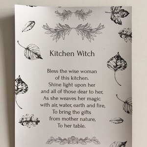 Puede incluir: Una tarjeta blanca con el texto "Kitchen Witch" y un poema. La tarjeta est&aacute; adornada con ilustraciones de hojas y dise&ntilde;os florales en blanco y negro, ideal para la decoraci&oacute;n de la cocina.