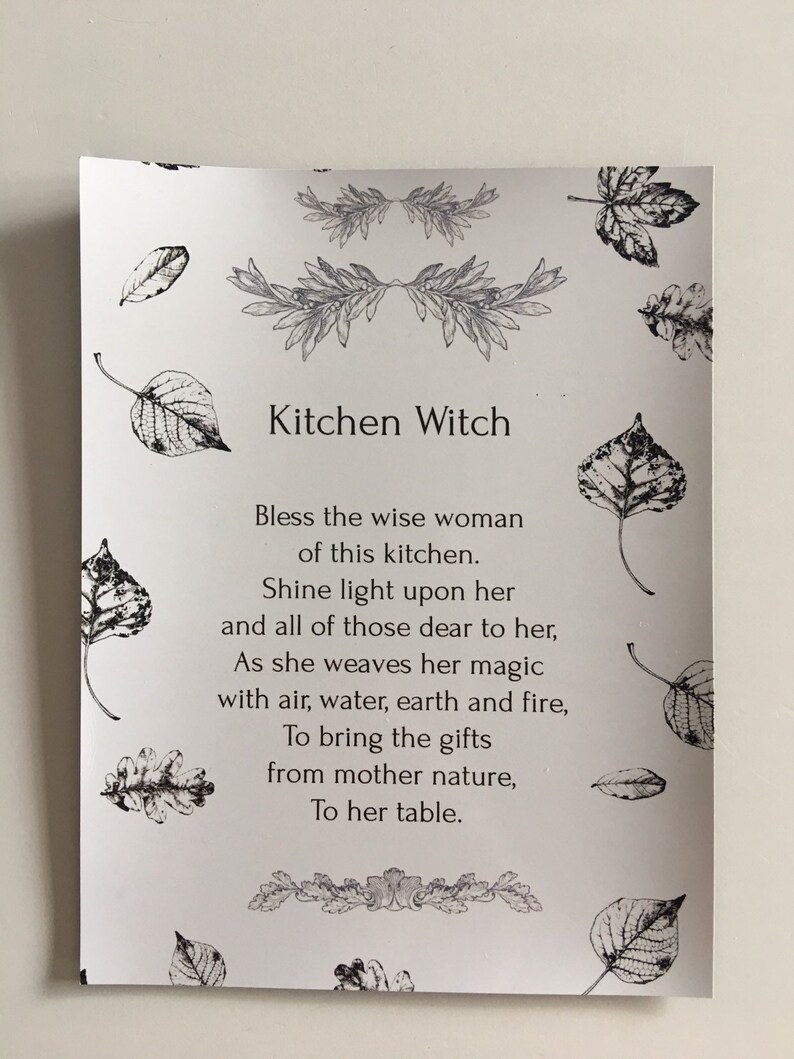 Puede incluir: Una tarjeta blanca con el texto "Kitchen Witch" y un poema. La tarjeta est&aacute; adornada con ilustraciones de hojas y dise&ntilde;os florales en blanco y negro, ideal para la decoraci&oacute;n de la cocina.