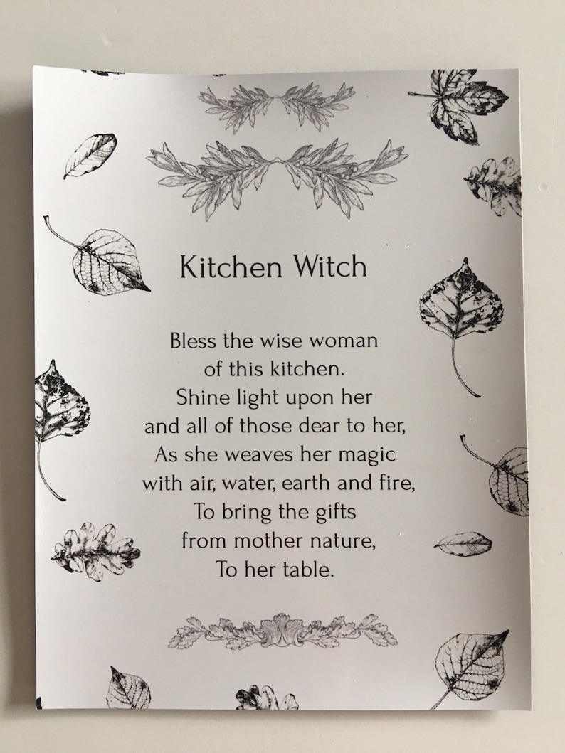 Puede incluir: Una tarjeta blanca con el texto "Kitchen Witch" y un poema. La tarjeta est&aacute; adornada con ilustraciones de hojas y motivos florales. El texto est&aacute; impreso en negro.