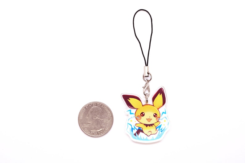 May include: A yellow and brown cartoon character with a black tail and ears, surrounded by blue lightning bolts, is printed on a clear plastic charm. The charm is attached to a black string and a silver metal clasp.