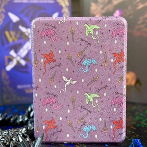 May include: A rectangular, lavender-colored case featuring a repeating pattern of colorful dragons, swords, and the word "Starlight." The dragons are in shades of red, pink, green, blue, and white.