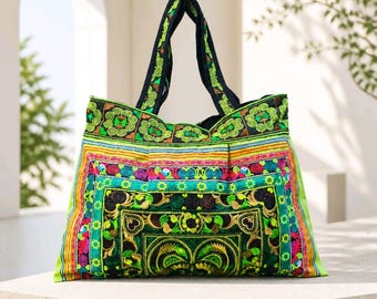 May include: A tote bag featuring intricate embroidery in vibrant shades of lime green, teal, black, and magenta. The design includes geometric patterns, swirling motifs, and floral shapes. It has two black fabric handles and a rectangular structure.